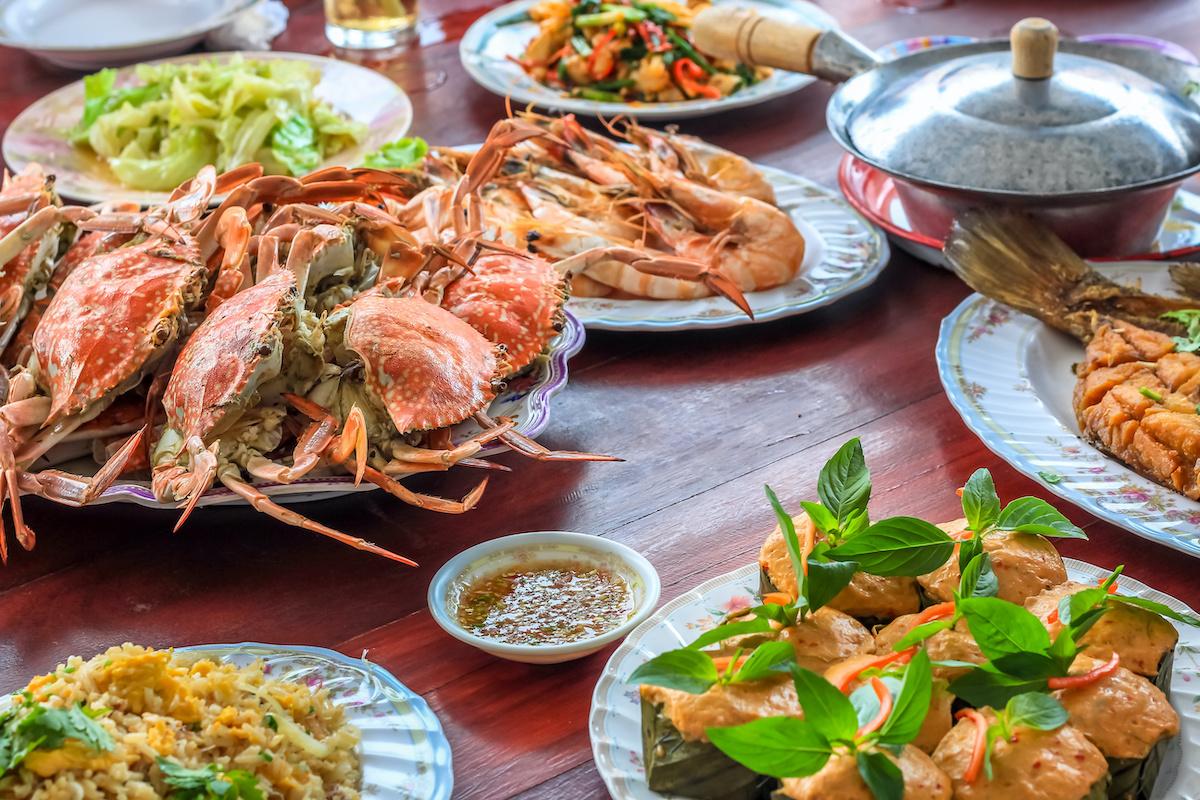 Article Cards Featured Image Thai style set of seafood insist of Thai steamed curry fish in banana leaf cups decorated with basil leaf,  Hor Mok Pla  steamed crab/prawn/shrimp with seafood sauce