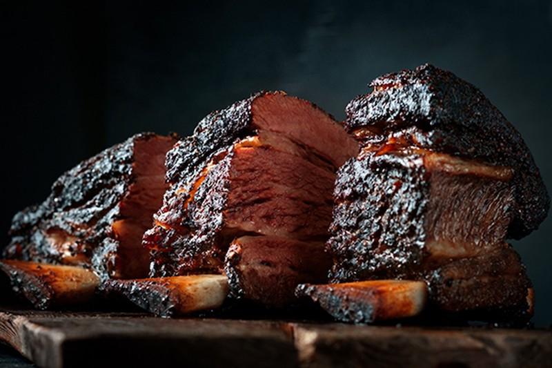 A closeup shot of. barbecue meat on a wooden plank.