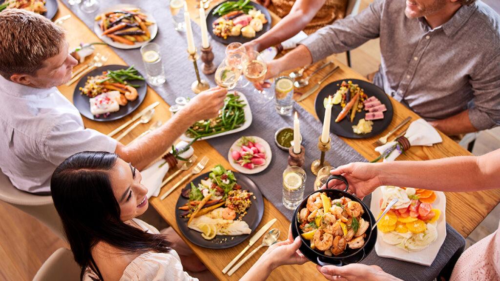 New Year's resolutions with a group of people sitting at a table eating dinner.