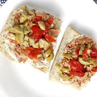 Niçoise salmon sandwich on a plate.