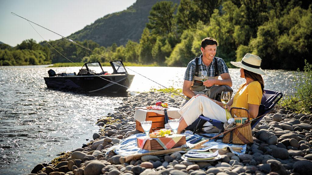 Outdoor couple smiling at each other while fishing.